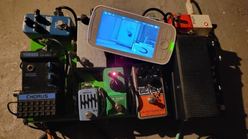 photograph of a pedalboard with a baby monitor on it