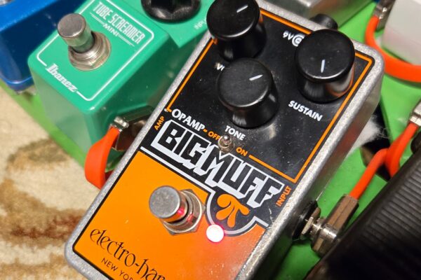 an electro-harmonix op-amp big muff engaged and on a pedalboard